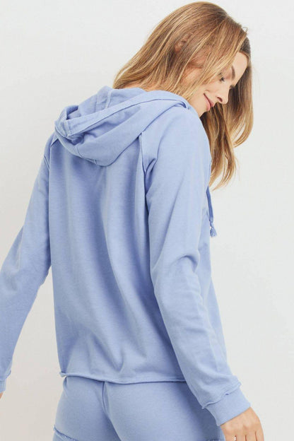 Woman wearing a light blue hoodie shorts on a plain background