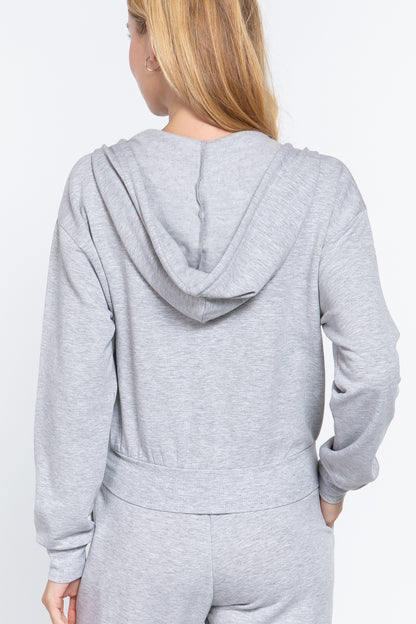 the back of a woman wearing a gray hooded fleece french terry jacket and matching pants on a white background