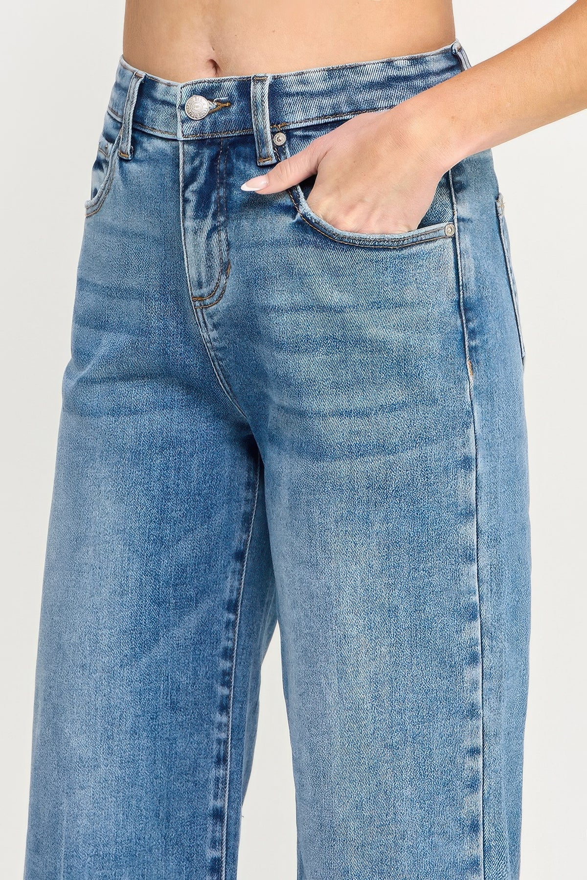 A women wearing Tummy Control Cropped Wide Leg Jeans with a frayed hem on a white background