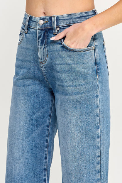 A women wearing Tummy Control Cropped Wide Leg Jeans with a frayed hem on a white background