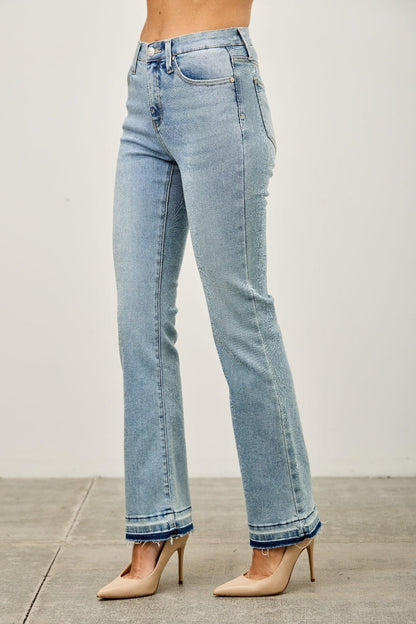 Light wash high-rise straight leg jeans with raw hem details, modeled with nude heels.