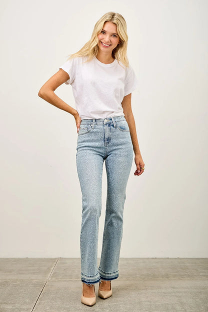 Woman wearing white t-shirt, high-waisted light wash straight-leg jeans, nude heels