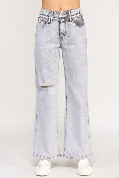 High-waisted light wash wide-leg jeans with distressed knee detail, styled with white sneakers