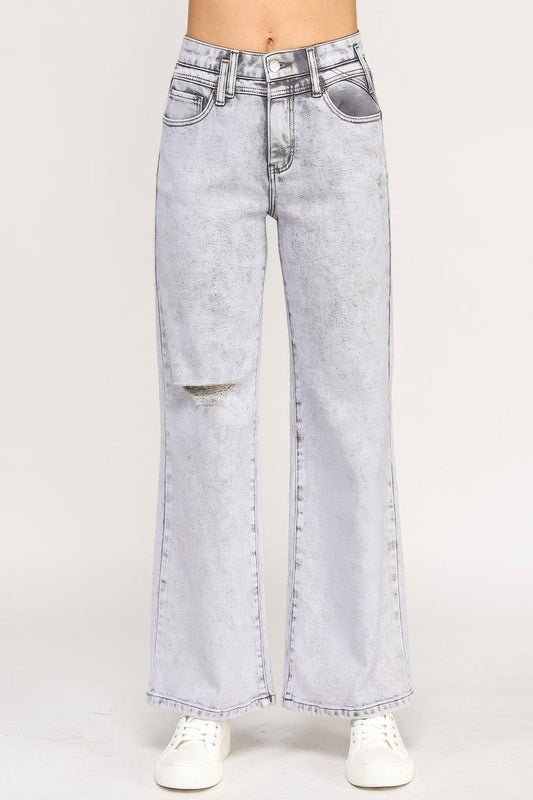 High-waisted light wash wide-leg jeans with distressed knee detail, styled with white sneakers