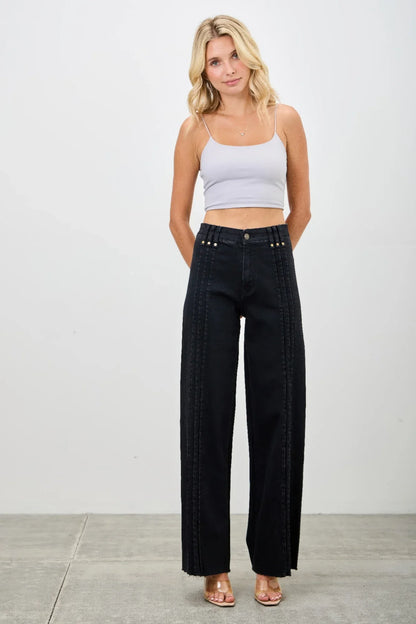 Woman in a light crop top and high-waisted wide-leg black jeans with contrast stitching