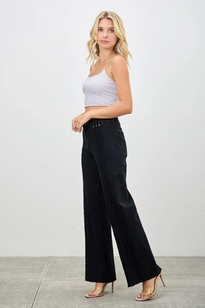 Woman in a white tank top and high-waisted black wide-leg pants with side stitch detail