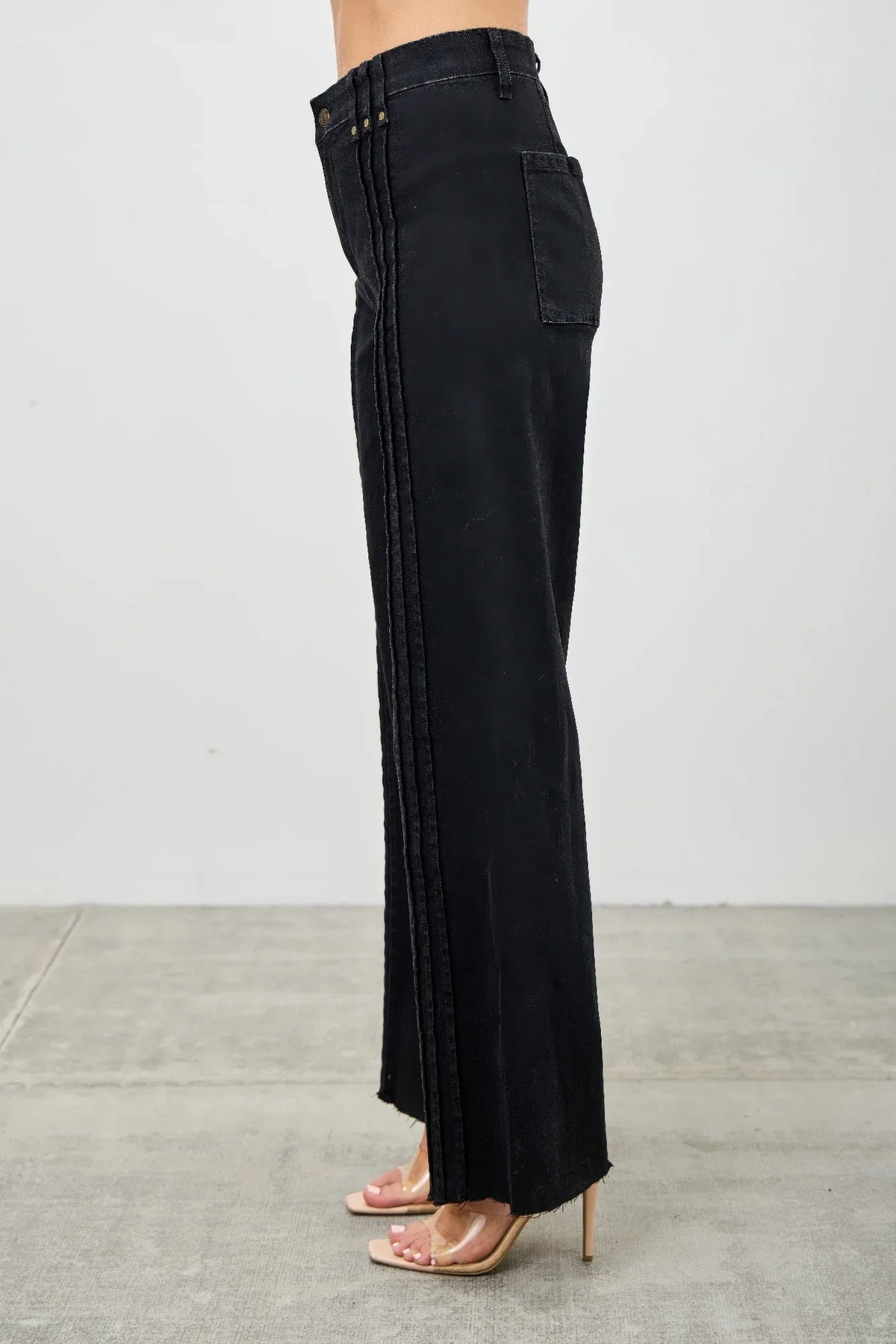 Side view of high-waisted black wide-leg jeans with vertical stitched details