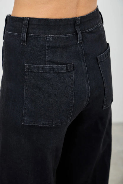 Back view of high-waisted black jeans with patch pockets and belt loops.