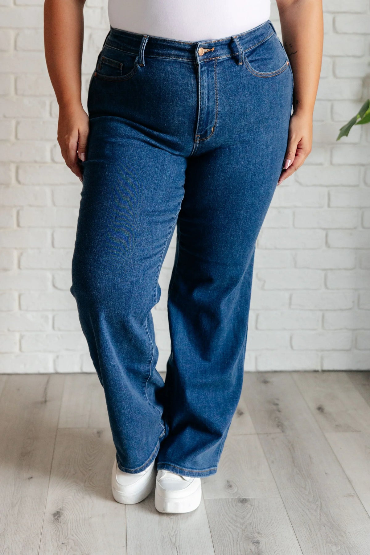 Woman wearing high-rise vintage wide leg jeans in dark blue, standing indoors