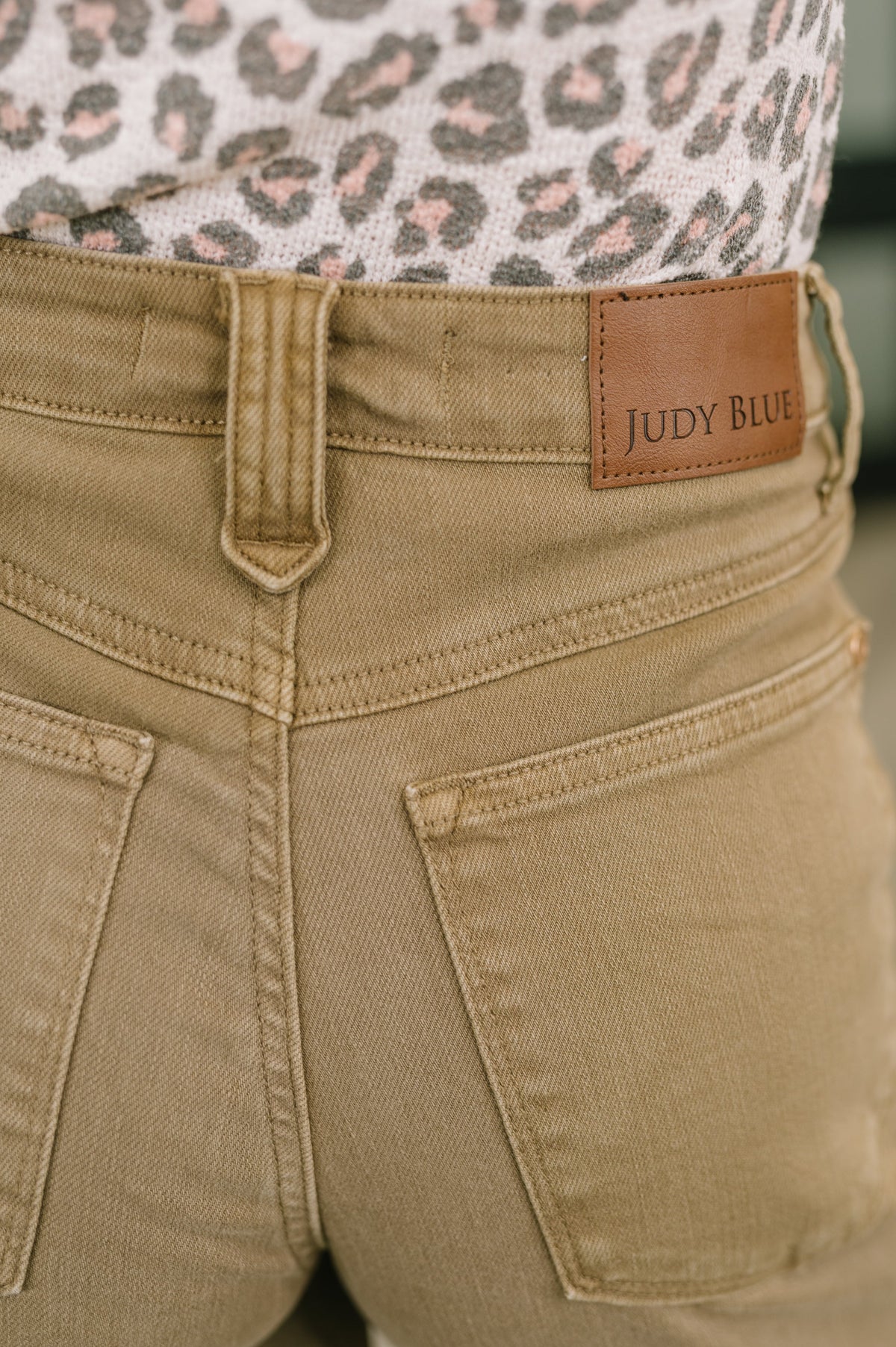 Close-up of beige pants with a brown label reading 'Judy Blue'.