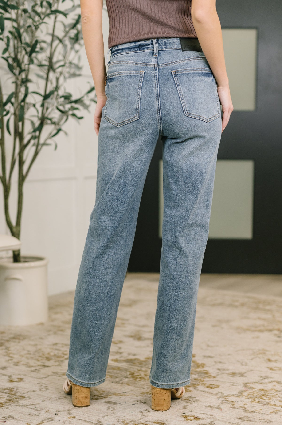 Person wearing light blue jeans with a blurred background