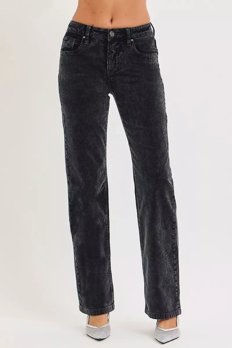 Woman wearing high-waisted black corduroy straight-leg pants and silver shoes