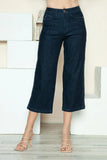 Woman wearing high-waisted dark denim wide-leg cropped jeans with strappy heeled sandals