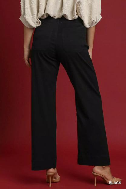 Back view of woman wearing black high-waisted wide-leg pants and nude heels