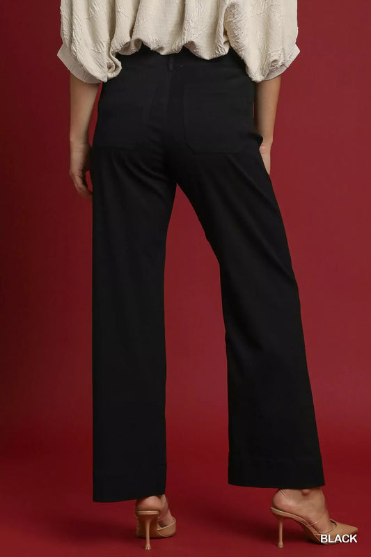 Back view of woman wearing black high-waisted wide-leg pants and nude heels
