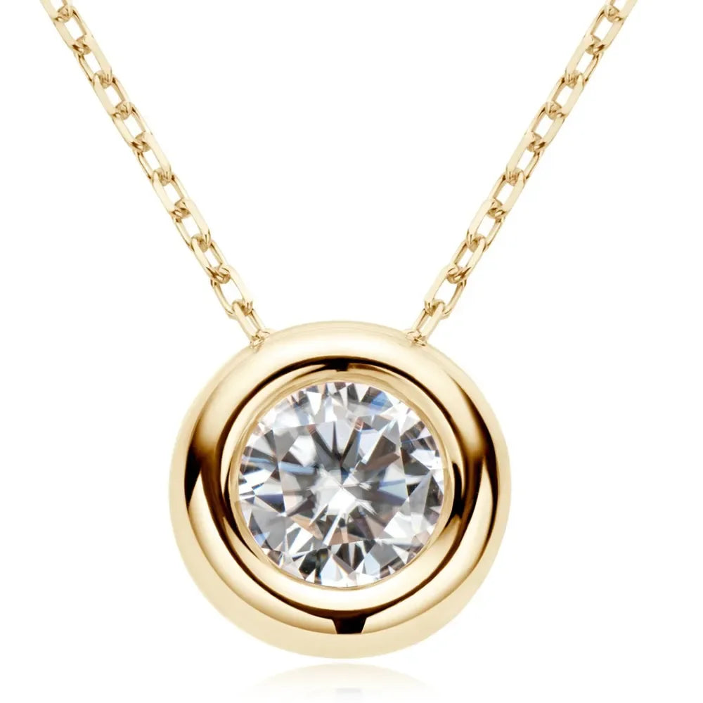 Gold chain necklace with round bezel-set clear gemstone pendant, modern minimalist style.
