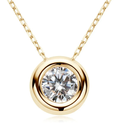 Gold chain necklace with round bezel-set clear gemstone pendant, modern minimalist style.