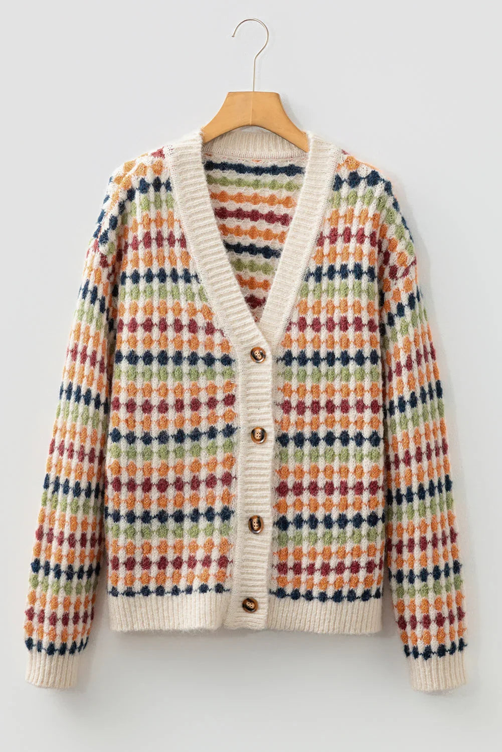 Multicolor patterned knit cardigan with button front and cream ribbed trim, hanging on hanger.