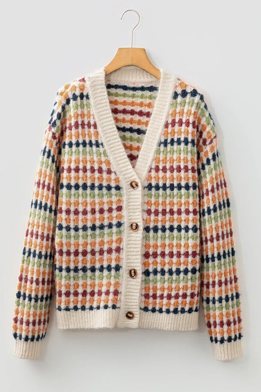 Multicolor patterned knit cardigan with button front and cream ribbed trim, hanging on hanger.