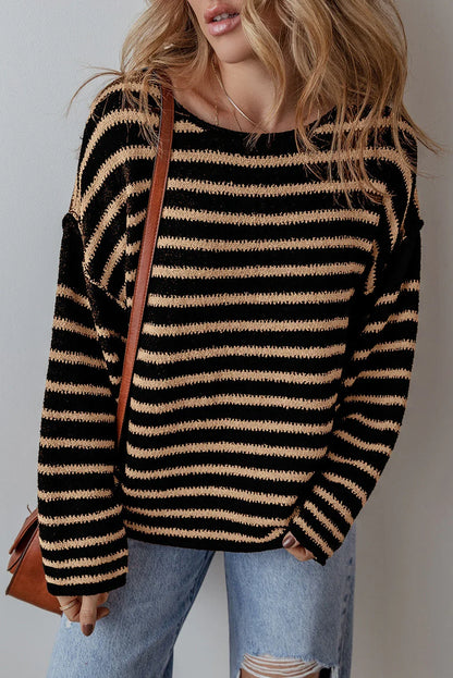Woman wearing black and beige striped knit sweater with distressed jeans and brown shoulder bag