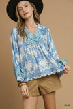 Woman wearing blue floral long-sleeve blouse with scalloped hem and khaki shorts