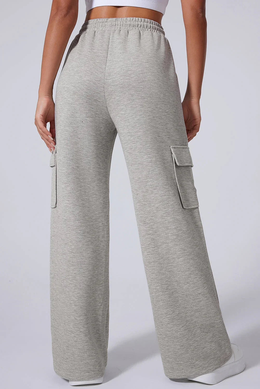 Back view of woman wearing light grey wide-leg cargo sweatpants with side pockets