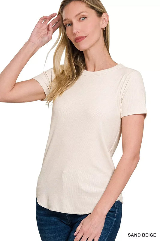 Woman wearing a sand beige short sleeve ribbed knit t-shirt and dark denim jeans.