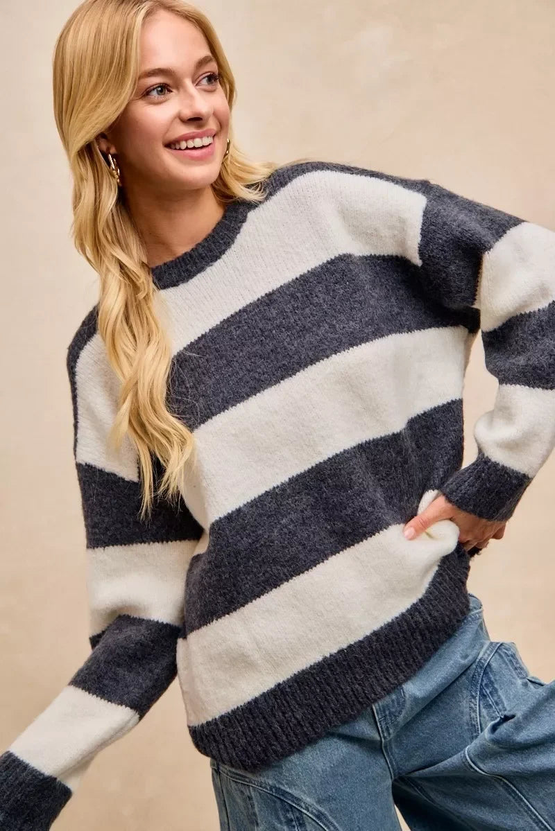 Woman wearing a cozy navy and white striped sweater with relaxed fit and blue jeans