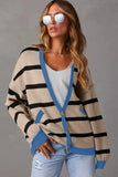 Woman in beige and black striped cardigan with blue trim, sunglasses, and light wash jeans.