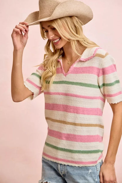 Woman in a pastel striped knit polo top and ripped denim shorts wearing a straw hat