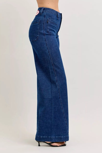 Side view of high-waisted wide leg blue denim jeans on model with black heels