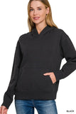 Woman wearing black relaxed fit hoodie with kangaroo pocket and blue jeans