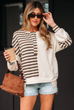 Woman in striped henley sweatshirt, denim shorts, brown suede bag, holding coffee