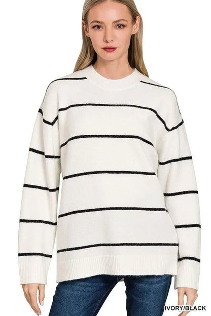 Woman wearing an ivory and black striped sweater with relaxed fit and long sleeves