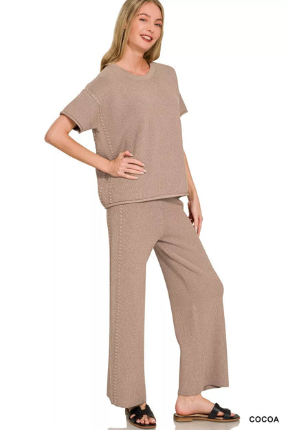 a woman wearing a taupe viscose round neck top pants set with black slides on a white background