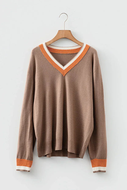 Brown V-neck sweater with orange and white trim on collar and cuffs, hanging on a hanger