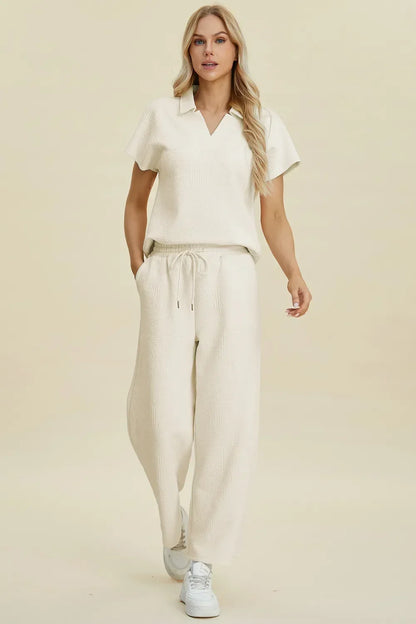 Woman wearing a cream textured short sleeve top and drawstring wide leg pants set