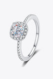 Cushion cut solitaire engagement ring with pavé band and halo setting on white background