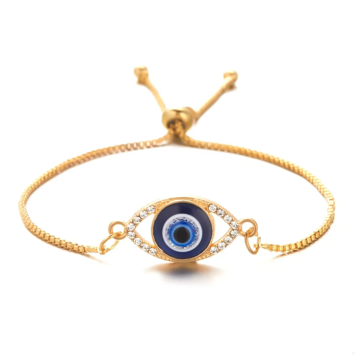 Gold adjustable bracelet with blue evil eye charm and clear crystal accents, isolated on white