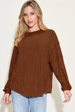 Woman wearing a relaxed-fit brown ribbed long sleeve top with light wash jeans