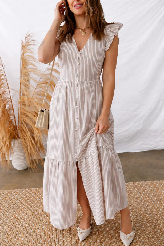 Woman wearing a striped, button-front midi dress with flutter sleeves and neutral heels