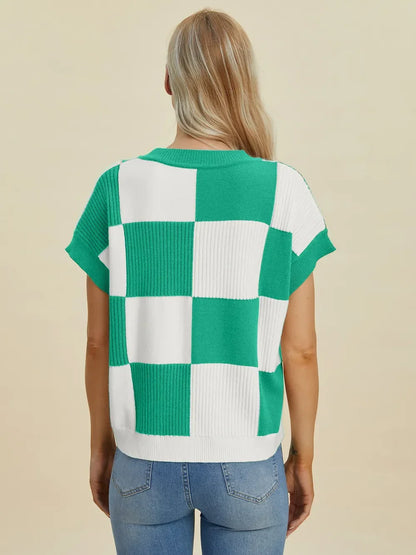 Woman wearing a green and white checkered knit short-sleeve sweater with blue jeans