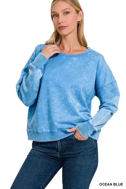 Woman wearing a relaxed fit ocean blue pullover sweatshirt with long sleeves and blue jeans