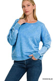 Woman wearing a relaxed fit ocean blue pullover sweatshirt with long sleeves and blue jeans