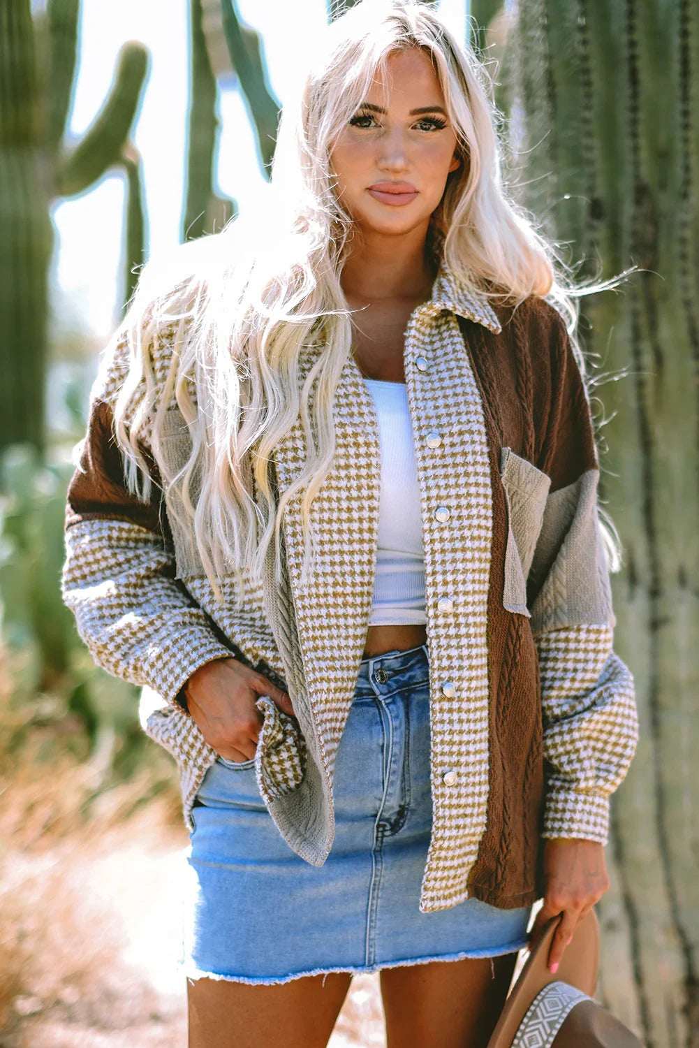 Woman wearing a houndstooth patchwork shacket and denim skirt outdoors