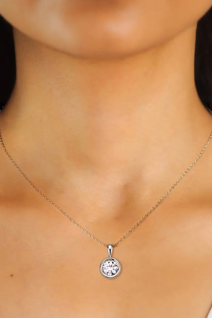 Delicate silver necklace with round solitaire pendant on woman's neck, minimalist jewelry