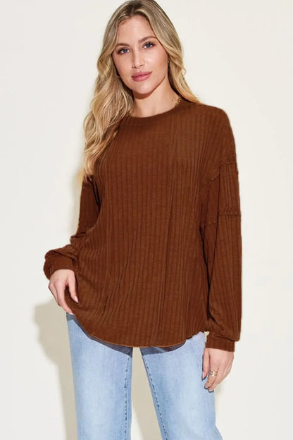 Woman modeling a brown ribbed long sleeve top with relaxed fit and light blue jeans