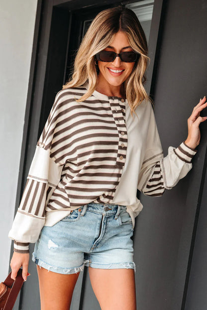 Woman wearing brown striped long sleeve henley top with light denim cutoff shorts