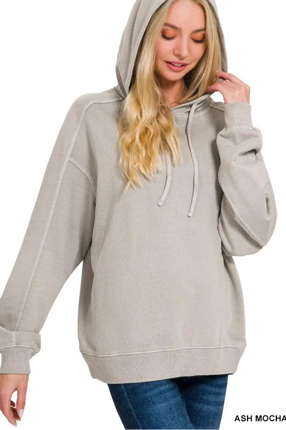Woman wearing a relaxed fit ash mocha hoodie with hood up, paired with blue jeans.