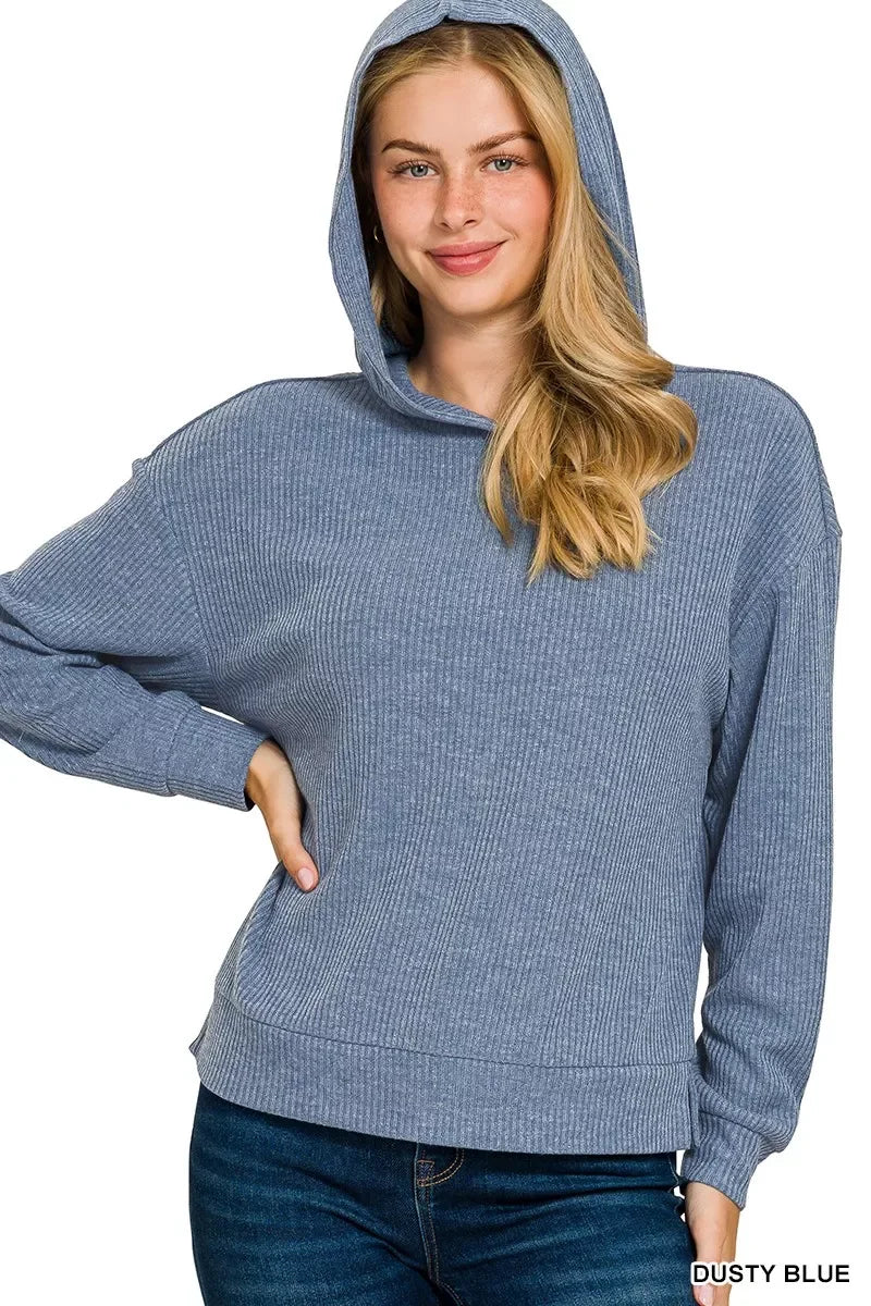 Woman wearing a dusty blue ribbed knit hoodie with relaxed fit and long sleeves.